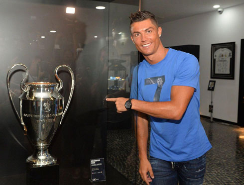 Cristiano Ronaldo pointing to the Champions League trophy