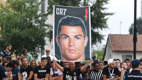 Fans holding big posters and banners with Cristiano Ronaldo face