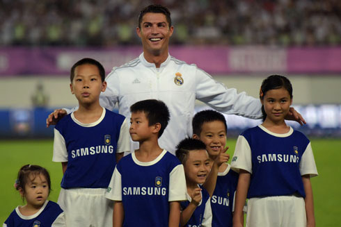 Cristiano Ronaldo taking a photo with Asian children