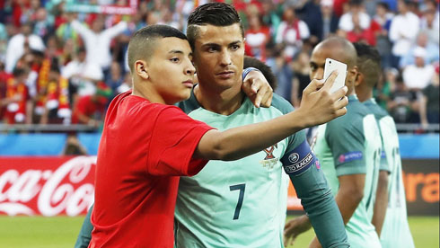 Cristiano Ronaldo taking photo with invader on the pitch