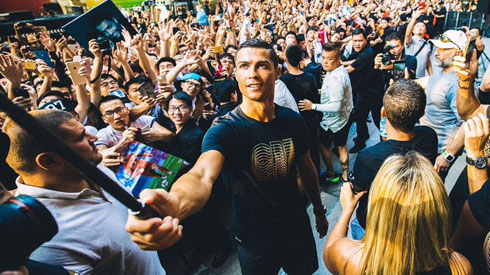 Cristiano Ronaldo taking photos with fans on his back