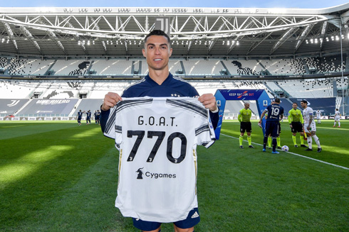 Cristiano Ronaldo holding a GOAT shirt