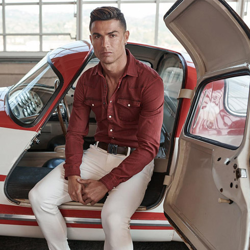 Cristiano Ronaldo posing for a photo next to a car