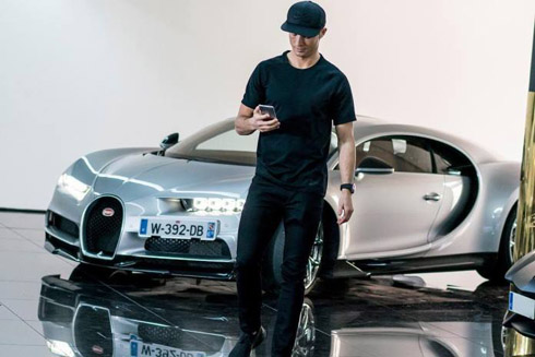 Cristiano Ronaldo standing in front of one of his cars the Bugatti Chiron