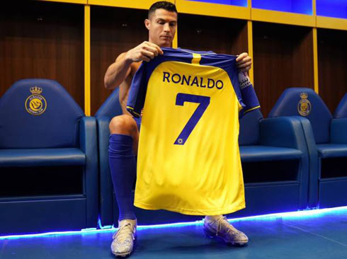 Cristiano Ronaldo holding his new shirt of Al-Nassr in 2023