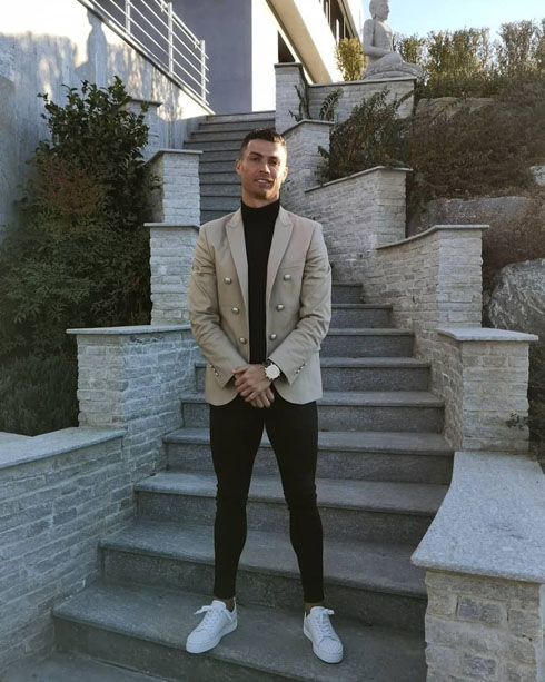 Cristiano Ronaldo taking a photo in front of the stairs of his mansion
