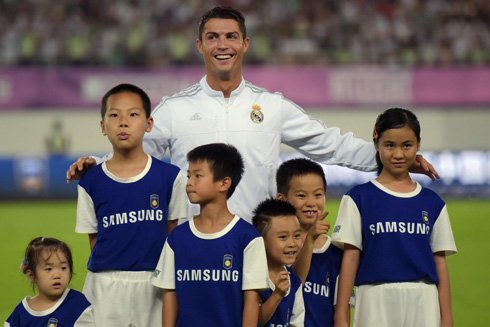 Cristiano Ronaldo posing for cameras next to children in Asia