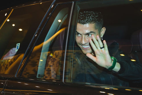Cristiano Ronaldo waving goodbye behind glass window inside car