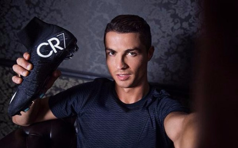 Cristiano Ronaldo holding his Nike signature boots