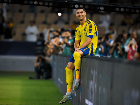 Cristiano Ronaldo sits on the advertising board in stadium
