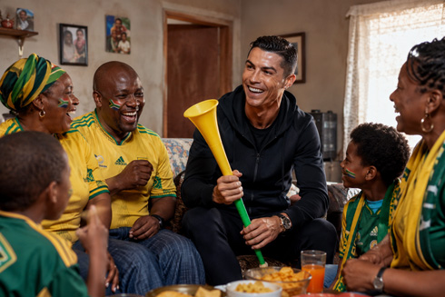 Cristiano Ronaldo holding a vuvuzela next to South African family