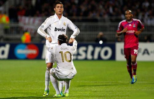 Cristiano Ronaldo helping Mesut Ozil to lift up
