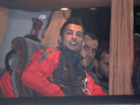 Cristiano Ronaldo hearing from his Ipod and looking from the bus window, with Ruben Micael observing next to him