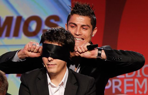 Cristiano Ronaldo applying a blindfold to a spectator, in a magic trick