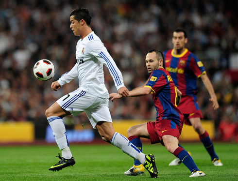 Cristiano Ronaldo playing against Iniesta and Busquets, in Real Madrid vs Barcelona