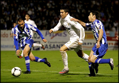 Cristiano Ronaldo running away in a sprint, escaping between two defenders in a Real Madrid match, for the Copa del Rey 2011-2012