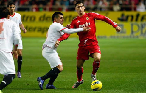 Cristiano Ronaldo being pushed by a Sevilla defender, in La Liga 2011-2012