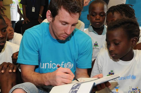 Lionel Messi giving an autograph to kids