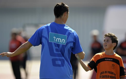 Cristiano Ronaldo reaching his hand to a young boy in a Portuguese National Team training session