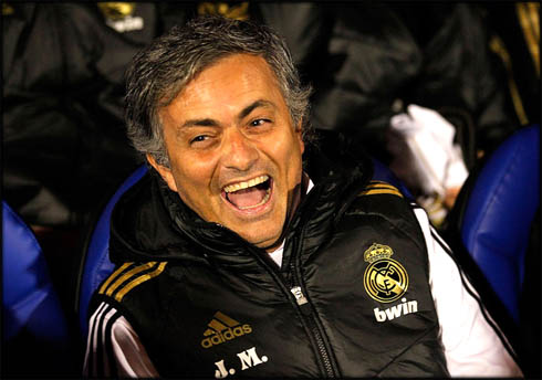 José Mourinho smiling at Real Madrid bench, wearing a black vest in 2011-2012