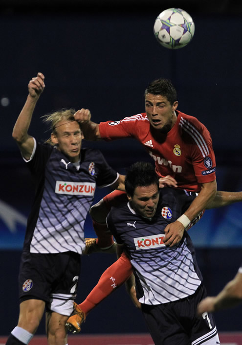 Cristiano Ronaldo jumping to head the ball, in Dinamo Zagreb vs Real Madrid, wearing a red Real Madrid shirt