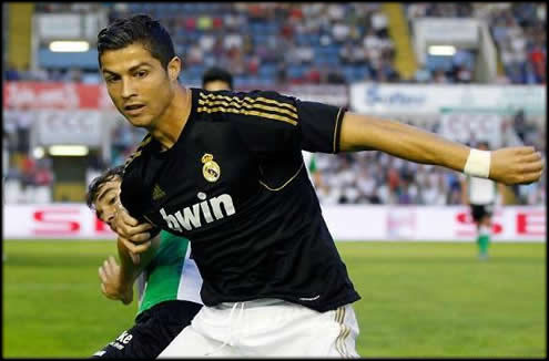 Cristiano Ronaldo protecting the ball with a defender pulling him in Racing Santander vs Real Madrid, La Liga 2011-2012