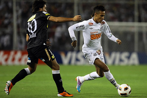 Neymar running with the ball, trying to get past the defender in a Santos game