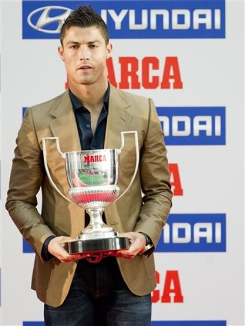 Cristiano Ronaldo posing for photos, while holding Marca's Pichichi award from his 41 goal record set in La Liga 2010/2011 campaign