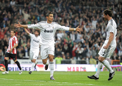 Cristiano Ronaldo runs with arms open, while Xabi Alonso arrives to join the celebrations