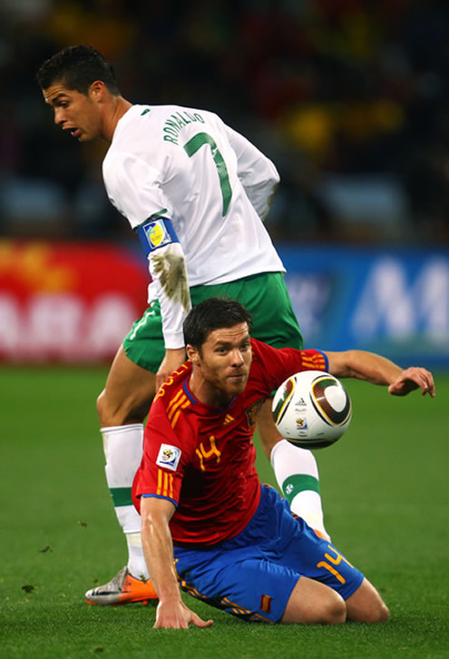 Cristiano Ronaldo and Xabi Alonso fighting for the ball, in a Portugal vs Spain match-up