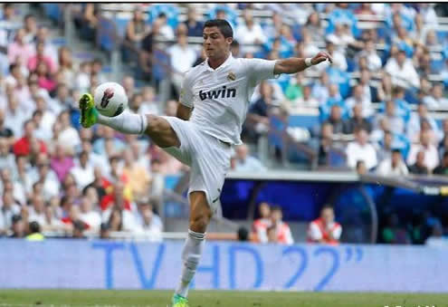 Cristiano Ronaldo shows his good flexibility as he reaches the ball with his fingertips