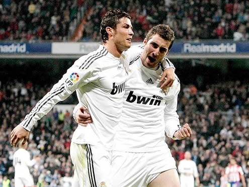 Cristiano Ronaldo and Gonzalo Higuaín holding each other, celebrating a goal for Real Madrid