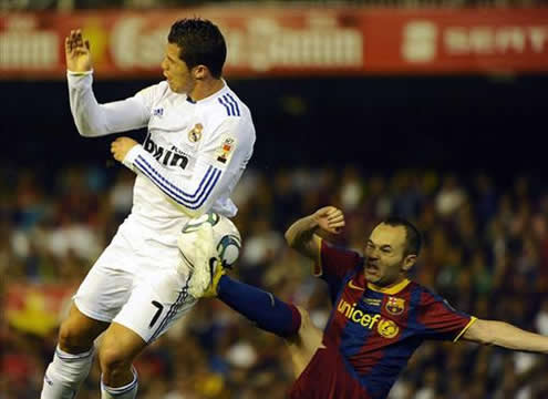 Andrés Iniesta reaching with his foot very high and harming Cristiano Ronaldo