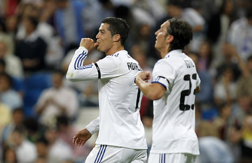 Cristiano Ronaldo with his thumbs on his mouth, with Mesut Ozil close to him
