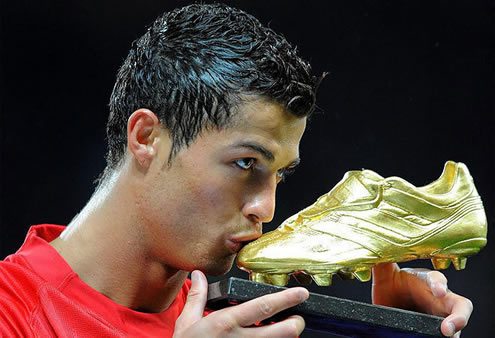 Cristiano Ronaldo holding and kissing the European Golden Shoe award in 2008, while still playing at Manchester United